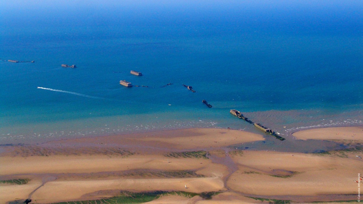 Blick aus der Luft auf die Reste von Landungsbooten an einem Strand