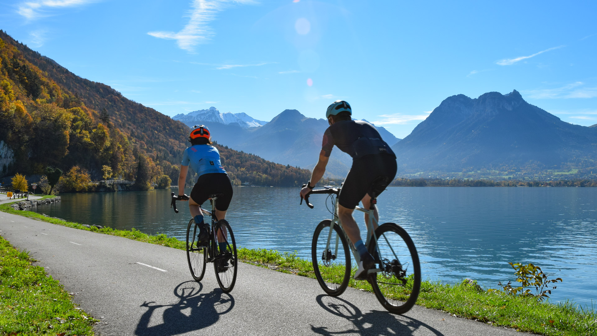 Zwei Rennradfahrer entlang des Sees von Annecy.