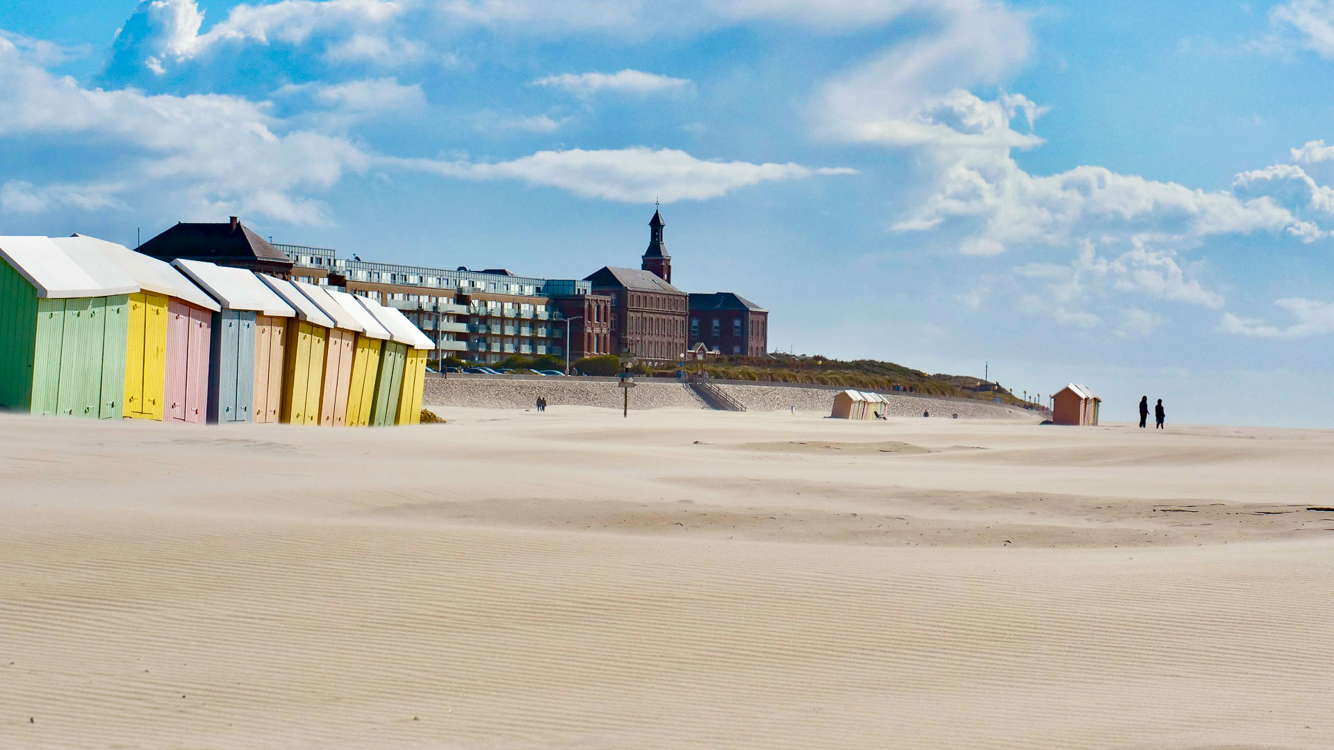 Typisch bunte Badehäusschen an einem weiten Sandstrand der Côte d'Opal.