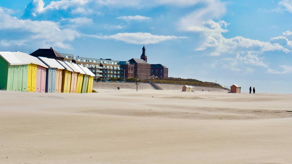 Typisch bunte Badehäusschen an einem weiten Sandstrand der Côte d'Opal.