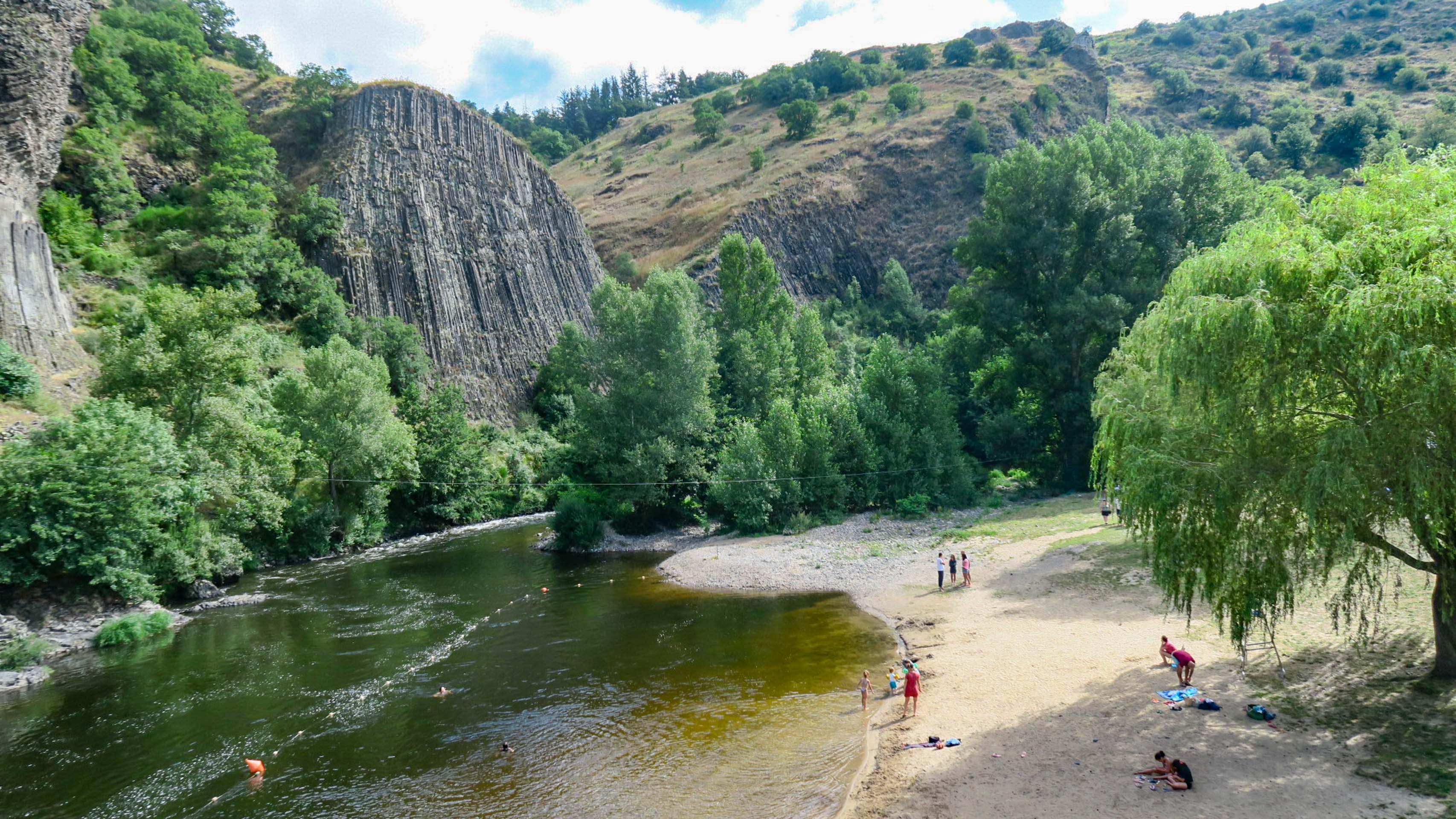 Typische Basaltsäulen oberhalb eines kleinen Strandes in der Allier-Schlucht.