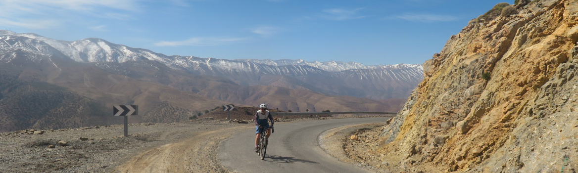 Homme à vélo gravel sur une petite route de l'Atlas marocain